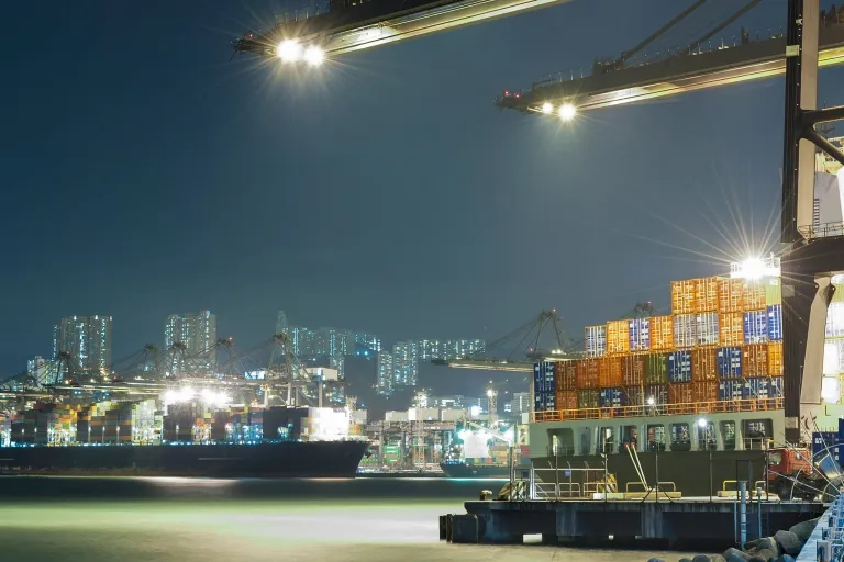 hell erleuteter Hafen bei Nacht, Schiffe, Kräne und Container